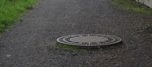 Kanaldeckel (mit Abschrgung) am Randweg Schleichenbach I